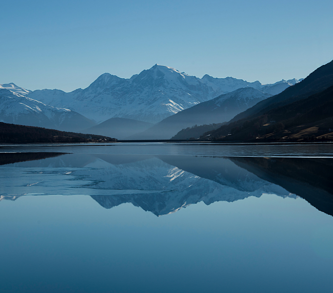 Far off mountain range reflecting in a still lake.