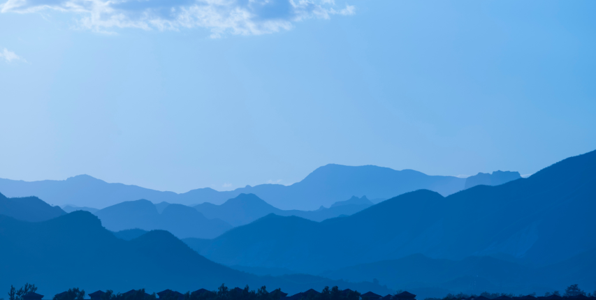 Several layers of far off mountain ranges with a blue color scheme.