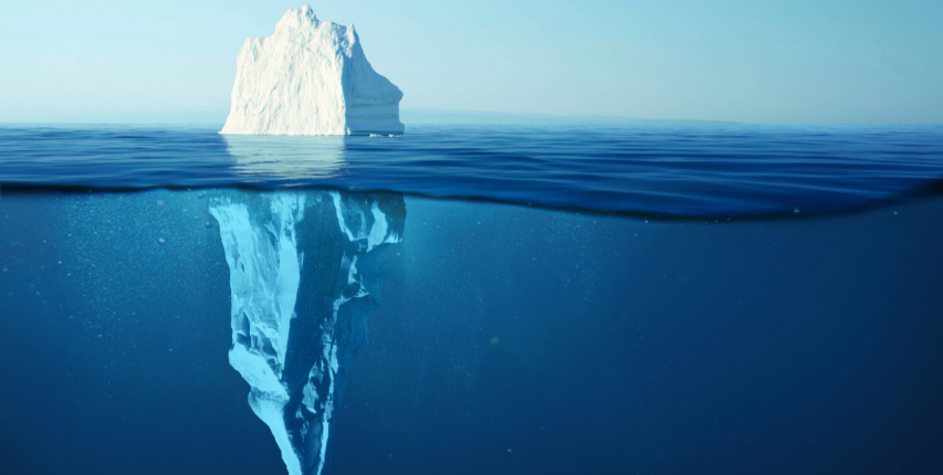 Floating white iceberg with the camera lens half above and half below the blue water surface.